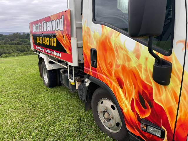 Betto’s Firewood Truck, front side view. Delivering Mixed Species Split Hardwood Firewood. 800kg, 1000kg, 1500kg to 2000kg load sizes available. All load sizes delivered Free Lismore to Ocean Shores. 1500kg and 2000kg load sizes delivered FREE from Casino & Tweed, Northern Rivers NSW. Every load receives a Free Kindling & Free Firelighters. Bag of free Kindling pictured. Firewood Ballina, Bangalow, Byron Bay, Brunswick Heads, Alstonville, Clunes, Mullumbimby, Pottsville, Kingscliff, Murwillumbah, Evans Head
