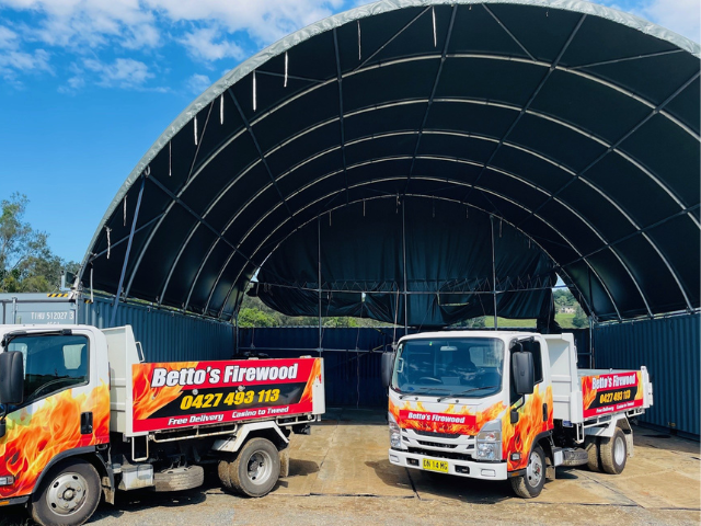 Betto’s Firewood Delivering Mixed & single Species Split Hardwood Firewood. Picture of trucks in timberyard with firewood piles in background. 800kg, 1000kg, 1500kg to 2000kg load sizes available. All load sizes delivered Free Lismore to Ocean Shores. 1500kg and 2000kg load sizes delivered FREE from Casino & Tweed, Northern Rivers NSW. Every load receives a Free Kindling & Free Firelighters. Bag of free Kindling pictured. Firewood delivered to Ballina, Bangalow, Byron Bay, Brunswick Heads, Alstonville, Clu