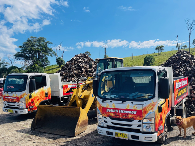 Betto’s Firewood Delivering Mixed & single Species Split Hardwood Firewood. Picture of trucks in timberyard with firewood piles in background. 800kg, 1000kg, 1500kg to 2000kg load sizes available. All load sizes delivered Free Lismore to Ocean Shores. 1500kg and 2000kg load sizes delivered FREE from Casino & Tweed, Northern Rivers NSW. Every load receives a Free Kindling & Free Firelighters. Bag of free Kindling pictured. Firewood delivered to Ballina, Bangalow, Byron Bay, Brunswick Heads, Alstonville, Clu