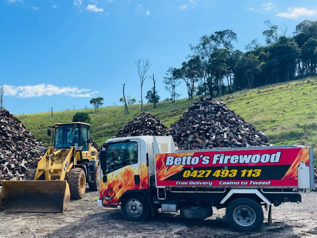 Betto’s Firewood Delivering Mixed & single Species Split Hardwood Firewood. Picture of tractor in timberyard with firewood piles in background. 800kg, 1000kg, 1500kg to 2000kg load sizes available. All load sizes delivered Free Lismore to Ocean Shores. 1500kg and 2000kg load sizes delivered FREE from Casino & Tweed, Northern Rivers NSW. Every load receives a Free Kindling & Free Firelighters. Bag of free Kindling pictured. Firewood delivered to Ballina, Bangalow, Byron Bay, Brunswick Heads, Alstonville, Clu